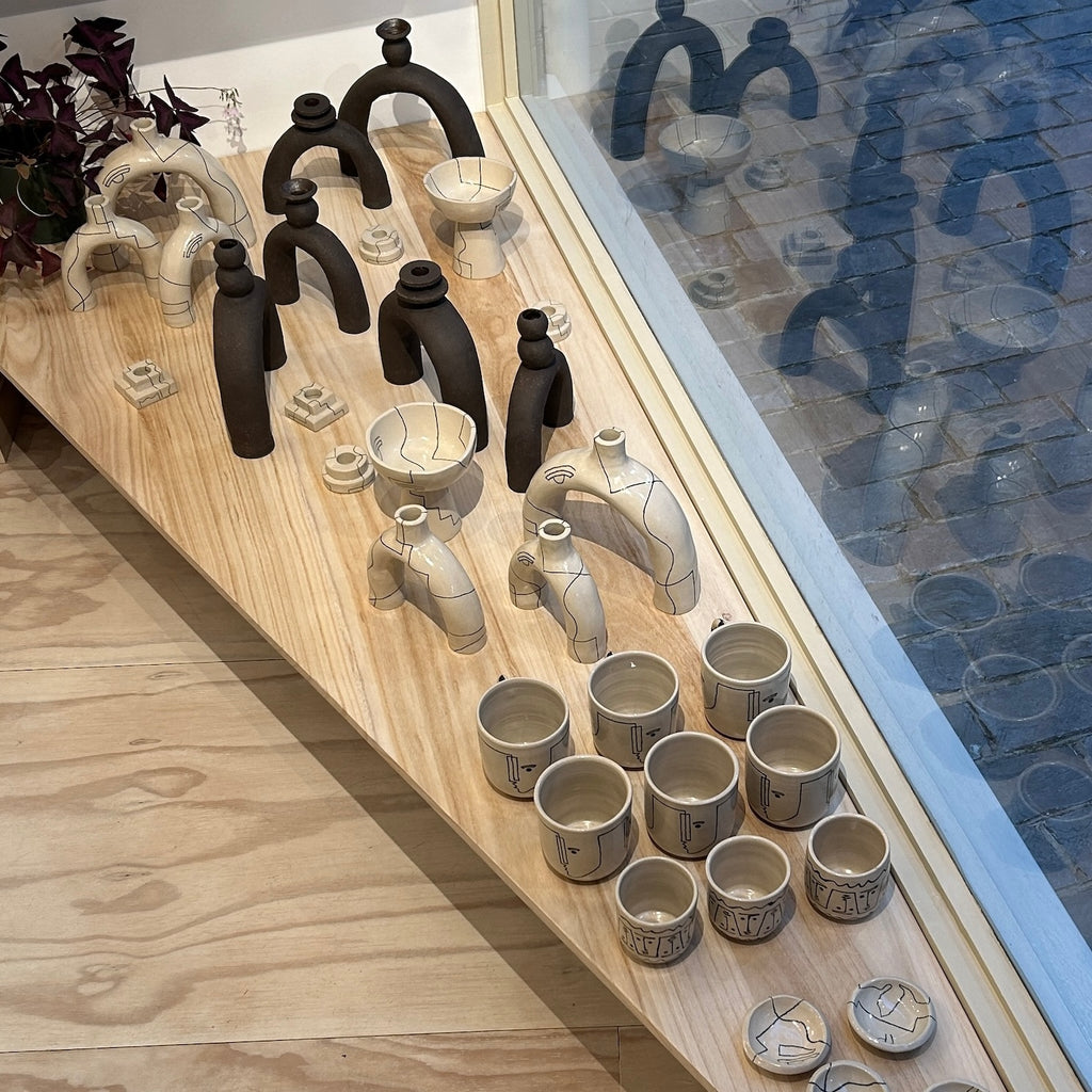 collection of HoodMor handmade ceramic pieces with a reflection in the window of Kentish Town Stores.