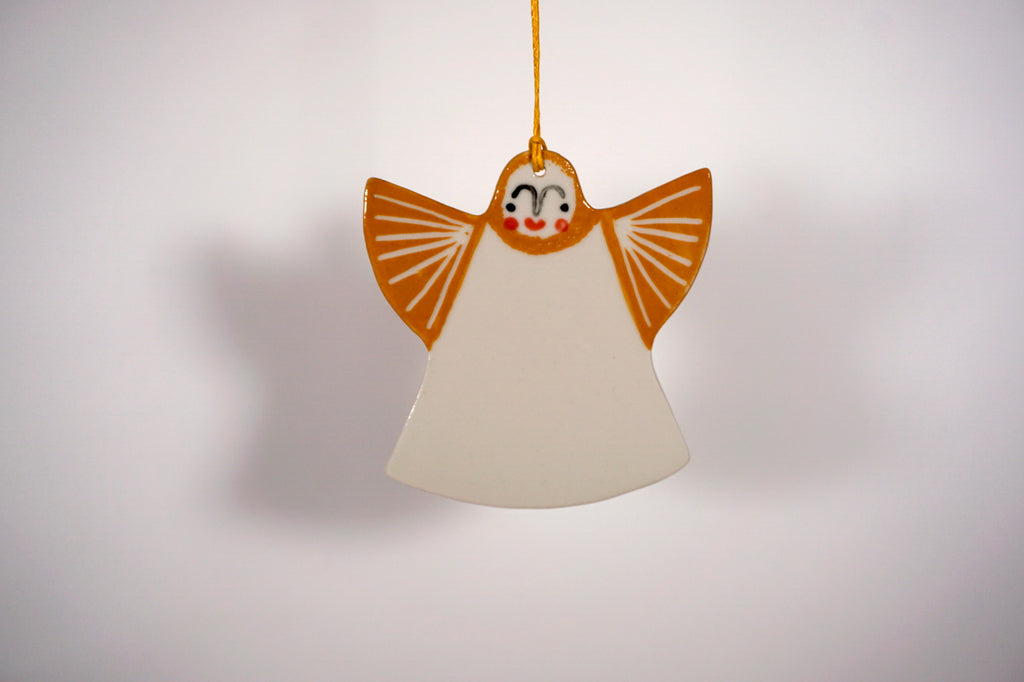 a hanging angel christmas decoration with a white dress and gold wings. 