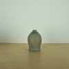 a small blue grey coloured handmade ceramic vase on a table. 