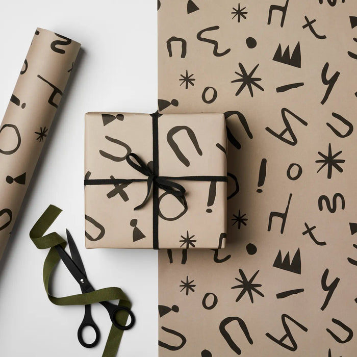 wrapped present sitting on top of a sheet of wrapping paper with the same pattern. 