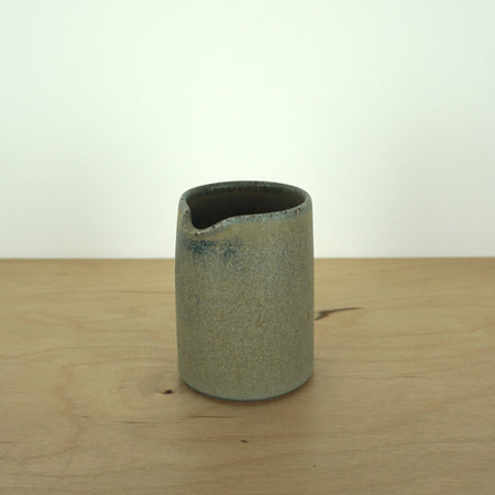 perfect straight blue milk jug handmade by Aku ceramics on a wooden table. 