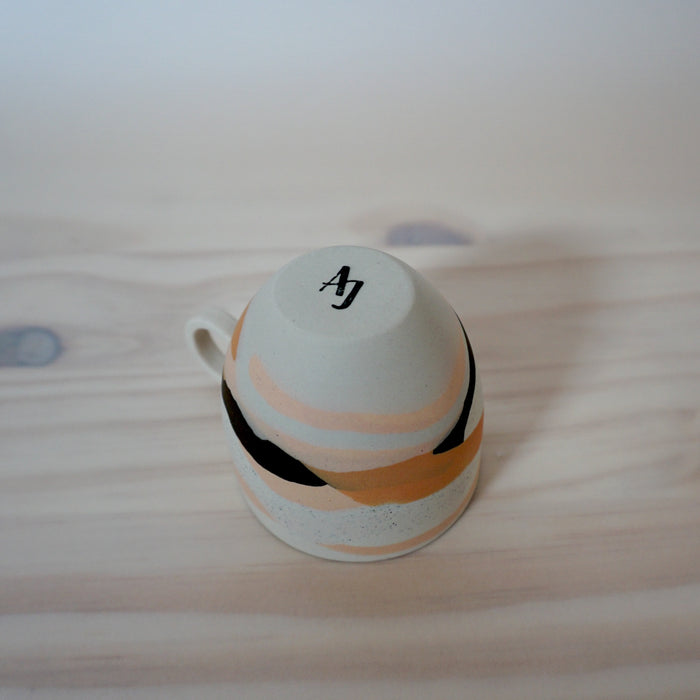 the base of a handmade porcelain espresso cup by anna jones ceramics showing her makers mark. 