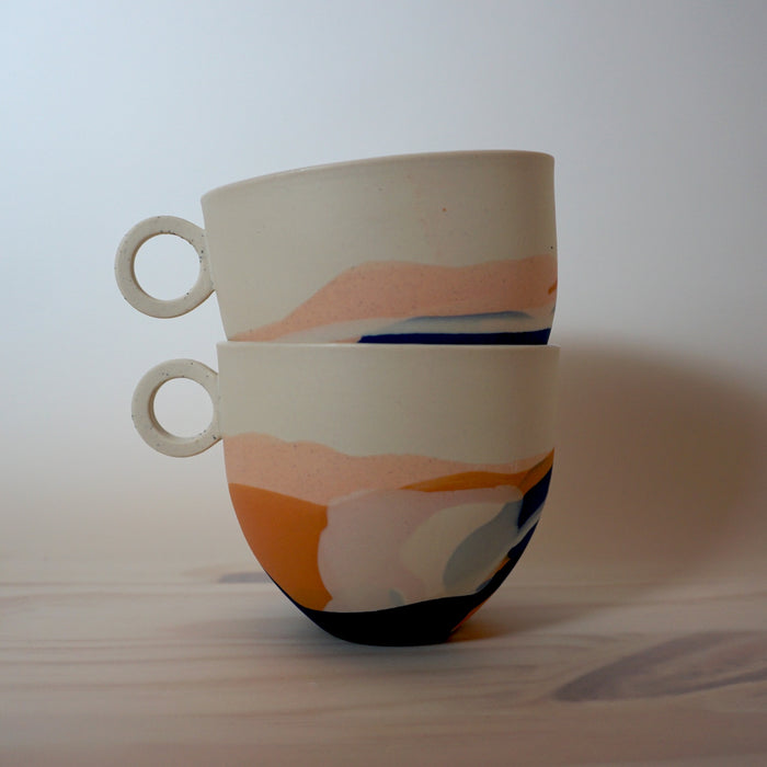 two mugs stacked in top of each other. decorated in marbled porcelain. 