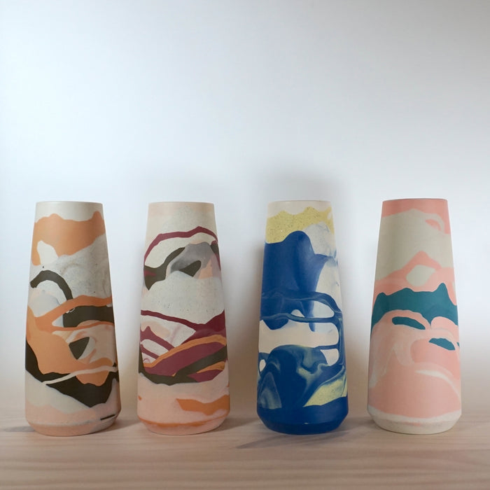 four marbled vases all different colourways in a line. 