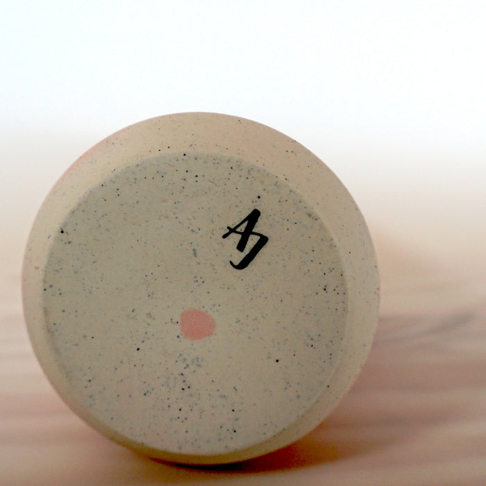 bottom of a handmade porcelain slipcast vase with the makers mark of Anna Jones Ceramics. 