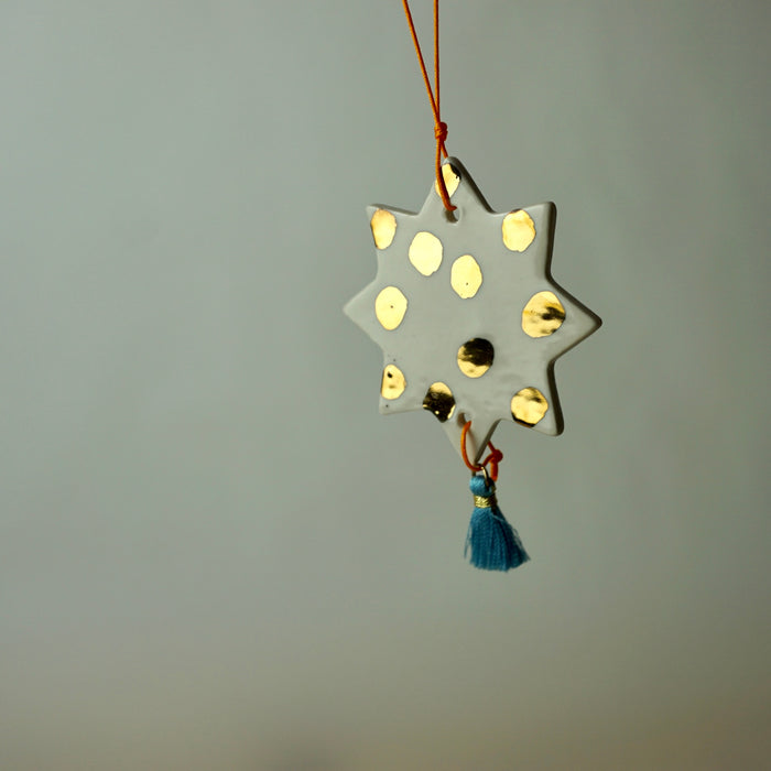 handmade ceramic Christmas decoration by Beci Callow with gold spots and colourful tassel. 