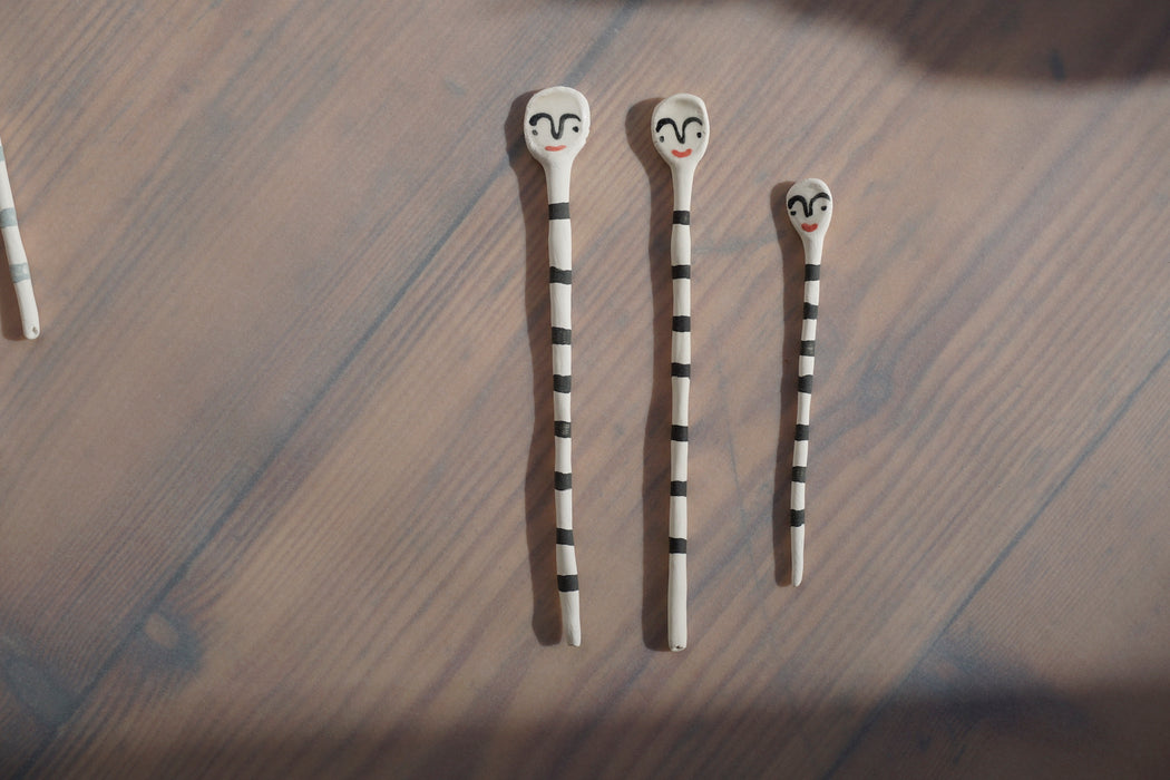 three porcelain salt spoons with stripes and faces by Beci Callow 