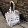 Costa Del Kentish Town Beach Bag sitting on a wooden bench. Kentish Town Stores