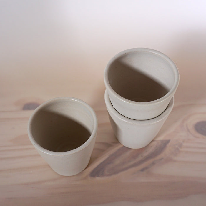 taken from above the detail of three white handmade coffee cups. 