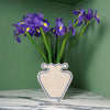 cream vase with blue outline pattern and a bunch of iris. 