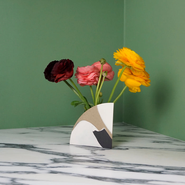 flowers in a bud vase on a marble table. 