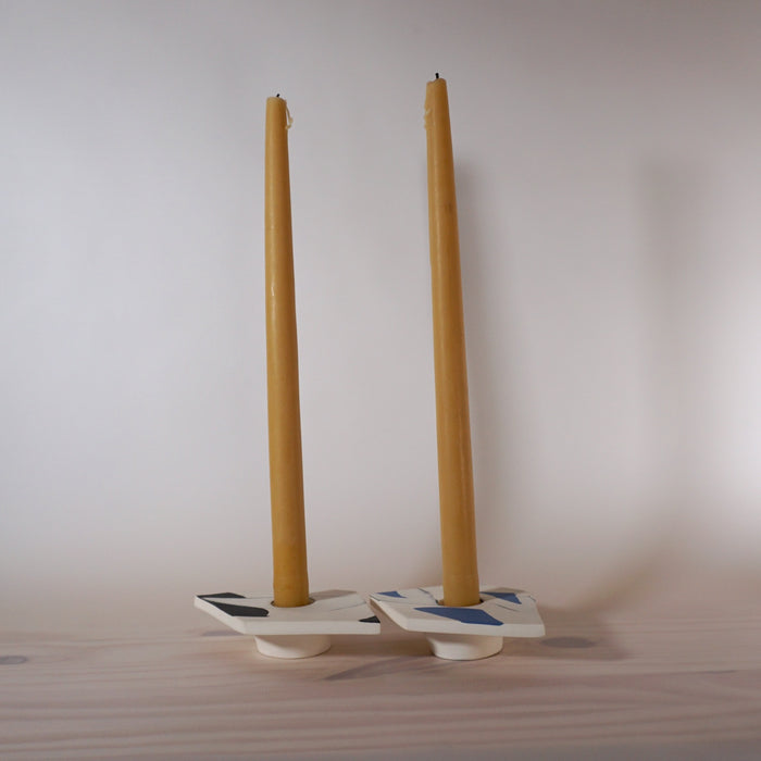 two low candlestick holders with two tall hand dipped uk beeswax candles in them available from Kentish Town Stores. 