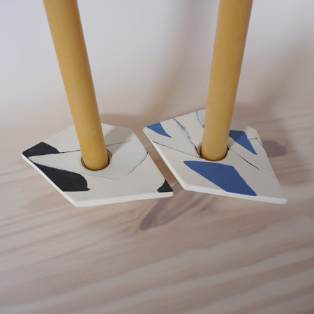 close up of two coloured porcelain candle holders with two hand dipped beeswax candles from Kentish Town Stores. 