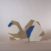 two handmade porcelain vases that are inspired by architectural forms sitting on a table. 