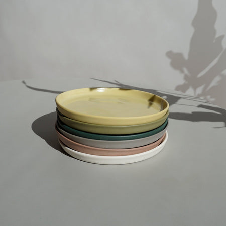 a stack of plates in Emma Johnson Ceramics signature colours. 