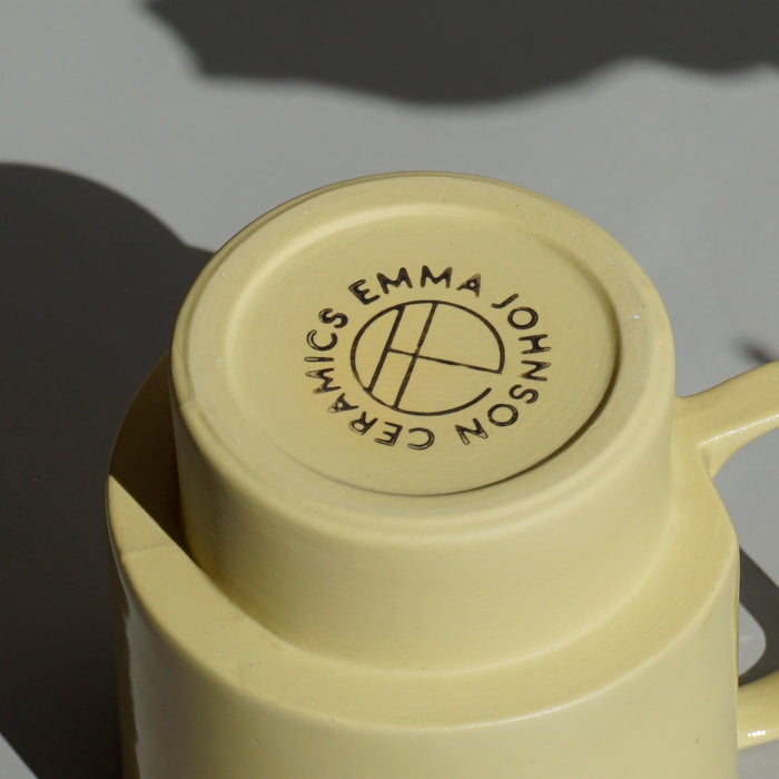 the base of a yellow handmade ceramic mug showing the maker mark of Emma Johnson Ceramics. 