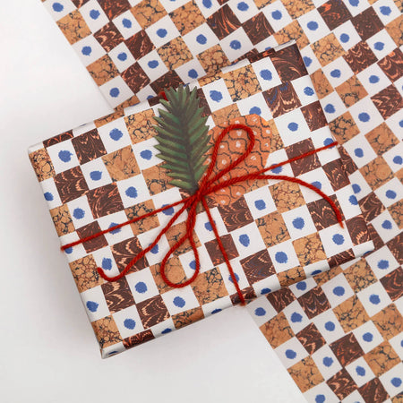 a present wrapped in brown and orange marbled gift wrap on a white background by Hadley Paper Goods. 