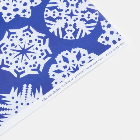 blue and white gift wrap in a snowflake pattern on a white background by Hadley Paper Goods. 