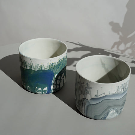 two planters in the sunlight with marble patterns on the porcelain 