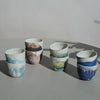 four pairs of marbled espresso cups on a table. 