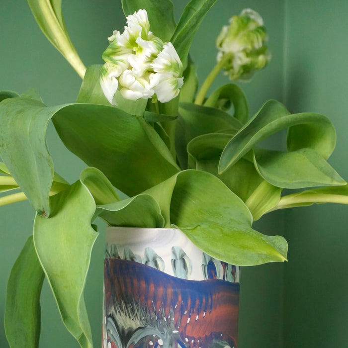 close up of green and white tulips in a marbled vase. 