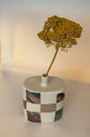 photographic transfers on a light coloured bud vase with a yellow dried flower. 