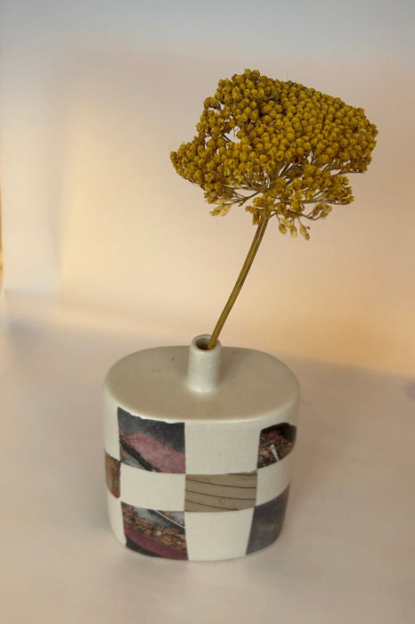 photographic transfers on a light coloured bud vase with a yellow dried flower. 