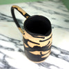 abstract black splatter ceramic jug with an oversized handle 