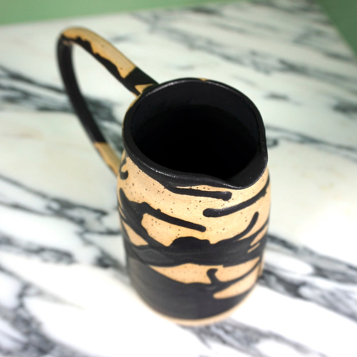 abstract black splatter ceramic jug with an oversized handle 