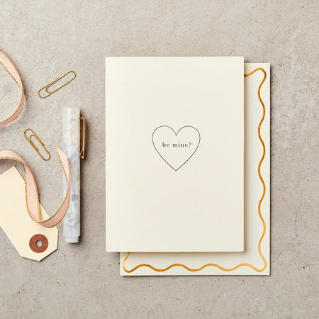 a card with a heart that says "be mine". 