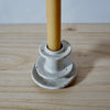 Close up detail of white handmade candlestick holder by Mae Ceramics with a Beeswax candle. 