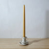 white handmade candlestick holder by Mae Ceramics with a Beeswax candle. 