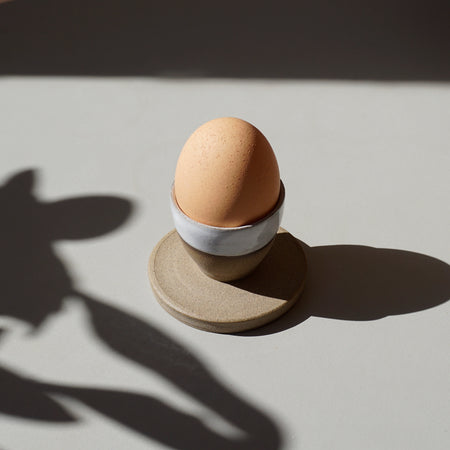 a stoneware egg cup, half glazed in white in the sunshine with an egg in it | Lily Pearmain | Kentish Town Stores 