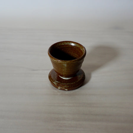 Handmade egg cup with an iron rich red glaze. 