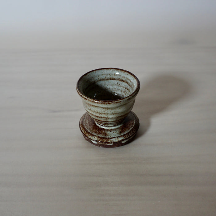 Handmade egg cup with a tin white glaze on red clay. 