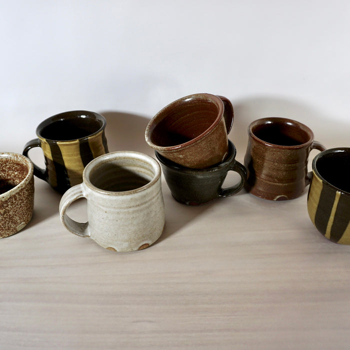 group of handmade ceramic mugs in lots of different glazes all by Lily Pearmain Ceramics. 