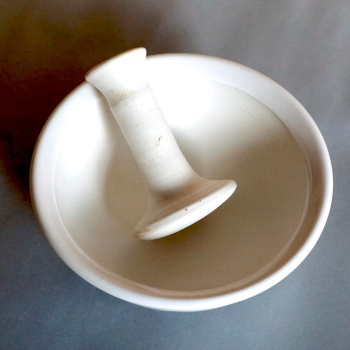 a white stoneware pestle & mortar