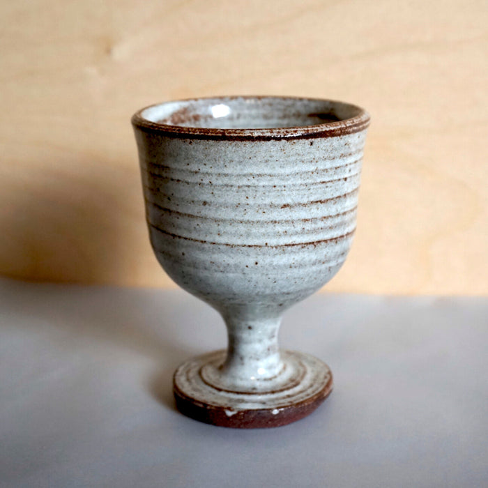 a handmade goblet with a tine white glaze on dark stoneware. 