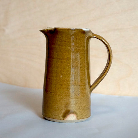 a nicotine brown colour milk jug from the side. 