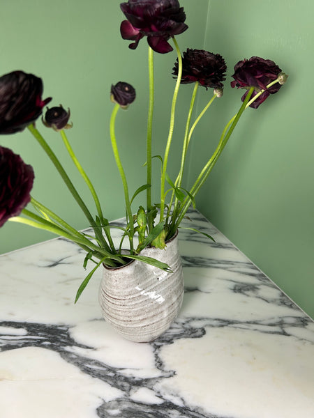 deep red flowers in a white vase. 