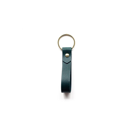 a green keyring with gold hardware on a white background. 