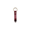 a red keyring with gold hardware on a white background. 