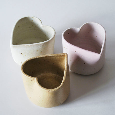 three handmade ceramic pots in the shape of hearts. 