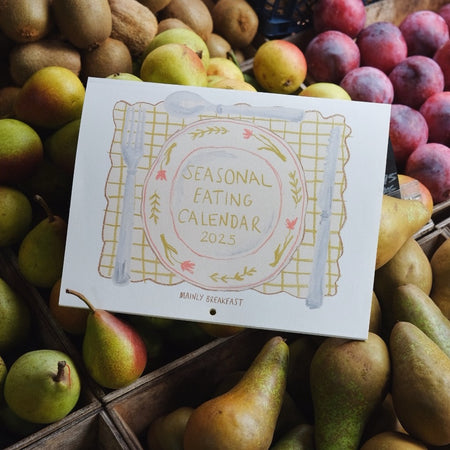 cover of a seasonal eating calendar in a basket of pears and plums.