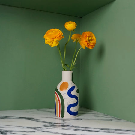 porcelain vase with abstract brushwork pattern and yellow flowers on a green background. 