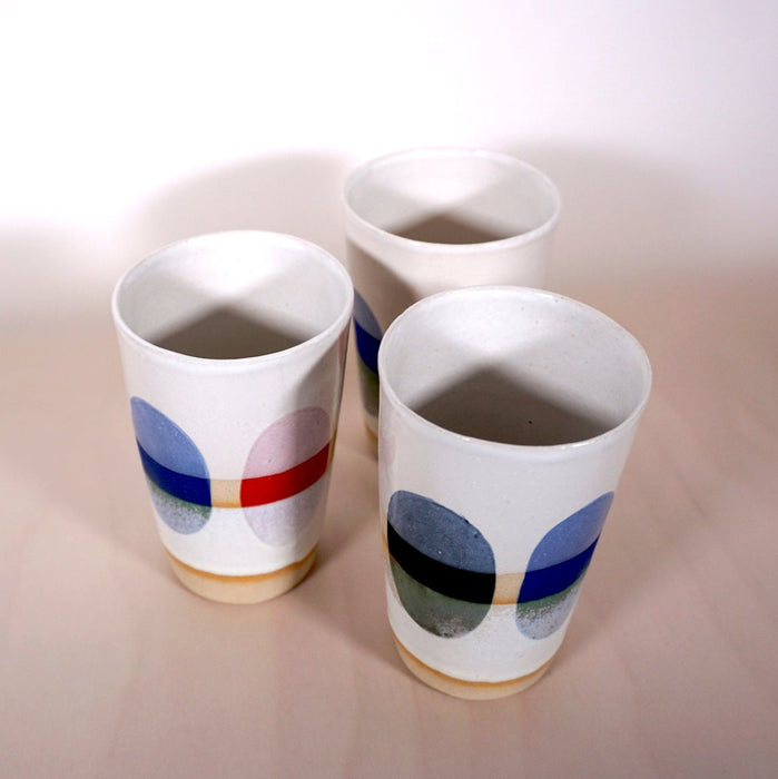 three cups with multi coloured dots painted around the side. 