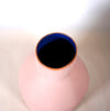 the top of a pink vase with a bright blue interior. 