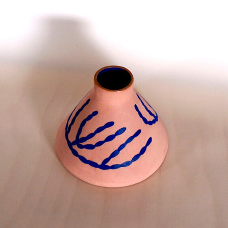 a pink cone vase with blue coral pattern hand painted on the surface. 