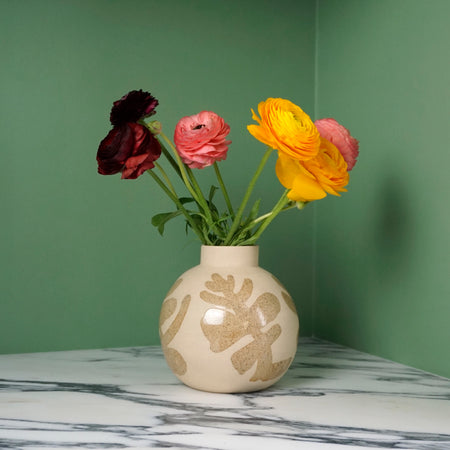 a stoneware vase with oatmeal decoration to represent a eucalyptus leaf. 