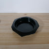 an angular dark glaze handmade serving bowl on a wooden table. 